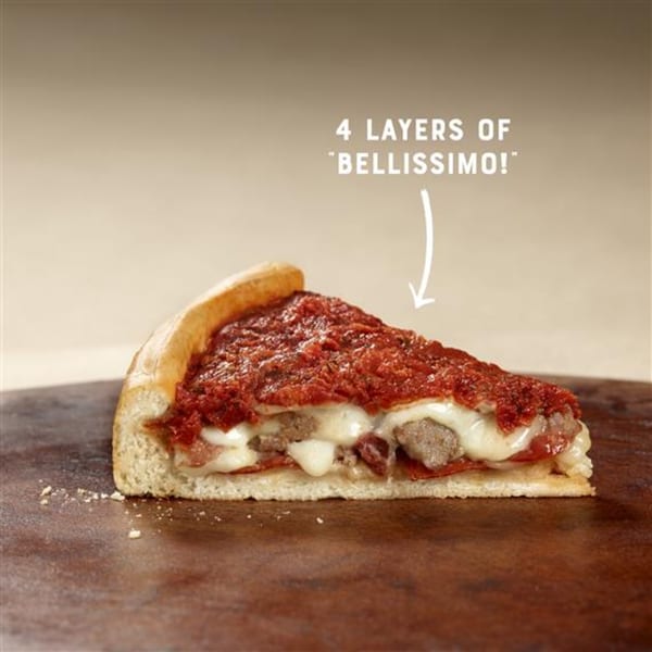 A thick slice of Sicilia's Pizzeria deep-dish pizza with four layers of toppings.